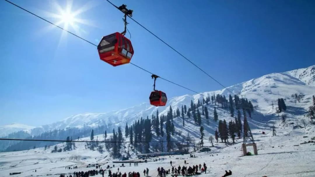 Aerial view of ropeway cabins travelling over valleys towards Auli