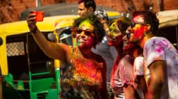 International tourists celebrating Holi at City Palace Udaipur with vibrant colours